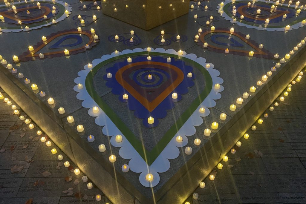 Colorful rangoli designs are surrounded by artificial candles.