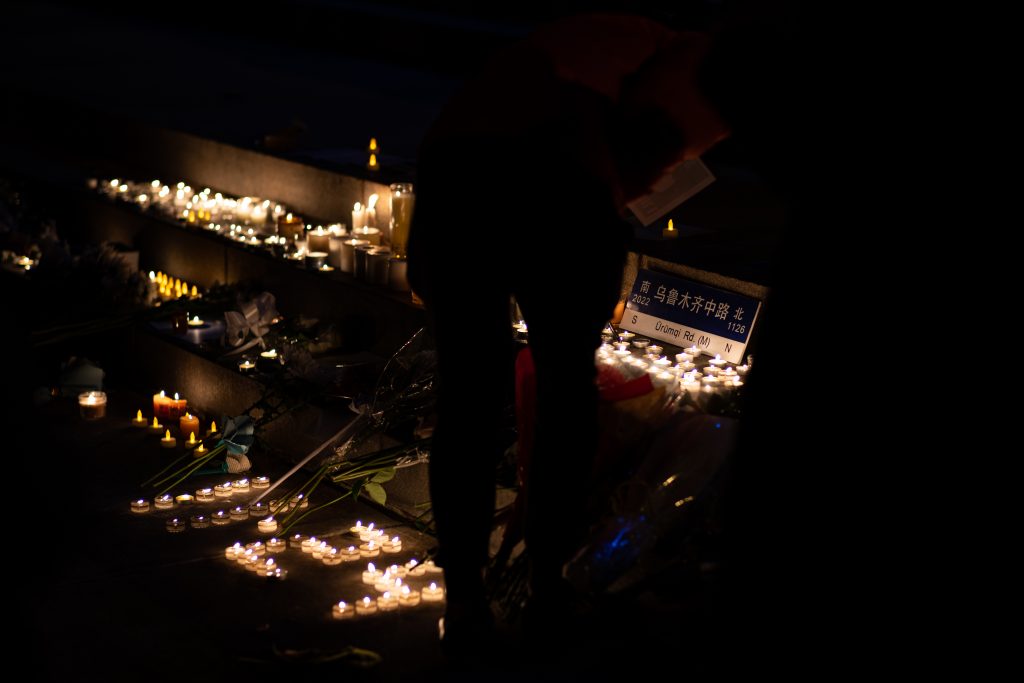 Flowers and candles encircling the road sign of Urumqi Road in Shanghai in front of Hendricks Chapel on November 28th, 2022, a symbol showing support for protests in China. Candles were arranged in the formation of 11.24, the date the fire in Urumqi happened.