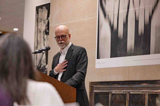 Bruce Strong, associate professor in Visual Communications at Newhouse and the Alexia Endowed Chair, speaks during the opening night of his Call to Me, Balkans photo exhibition in Panasci Lounge located on the third floor of Schine Student Center. The exhibition features photos, all of which were made on his iPhone, from his 2023 sabbatical and two successive trips to Bosnia. Claudia Strong, an adjunct in Visual Communications at Newhouse and also Bruce’s wife, curated and designed the exhibition.