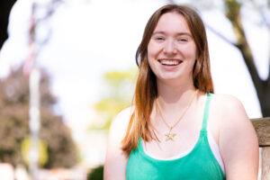 University Union President Kate McKenna in a green blouse sits near the Quad on Thursday.