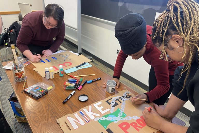 SILS members make protest signs calling on Syracuse to cut ties with Nike.