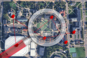 A birds-eye view of the Syracuse University Campus with red pins connected by red string on each building the Syracuse Pisser vandalized. A semi-translucent magnifying glass rests over the campus.