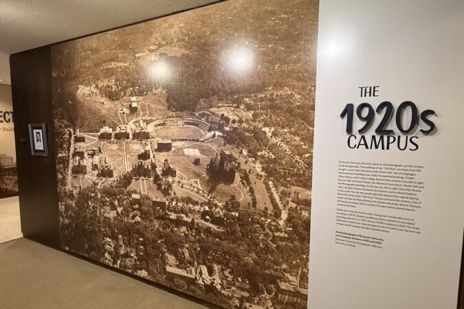 A wall expansive image of an aerial view of the early 1920s SU campus. Beside the image is a written passage describing the image and history with a larger heading above: "The 1920's Campus"
