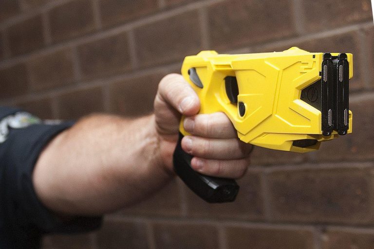 Camden County Police John Martinez points a taser gun that is equipped with a camera on the bottom of the handle in this file photo.