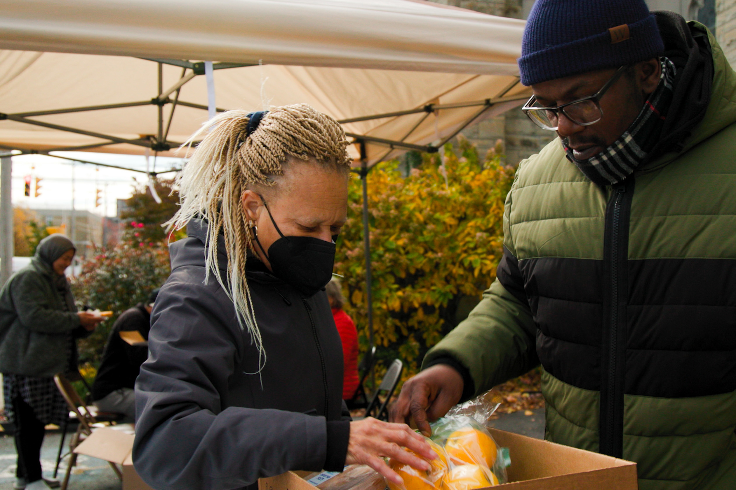 Syracuse residents review a food box provided by the Interfaith Community Collective