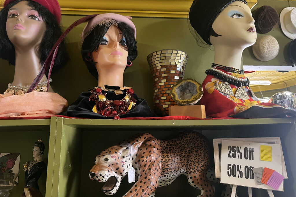 An eclectic assortment of vintage apparel lines a display shelf at Cluttered Closet Consignment on South Beech Street.