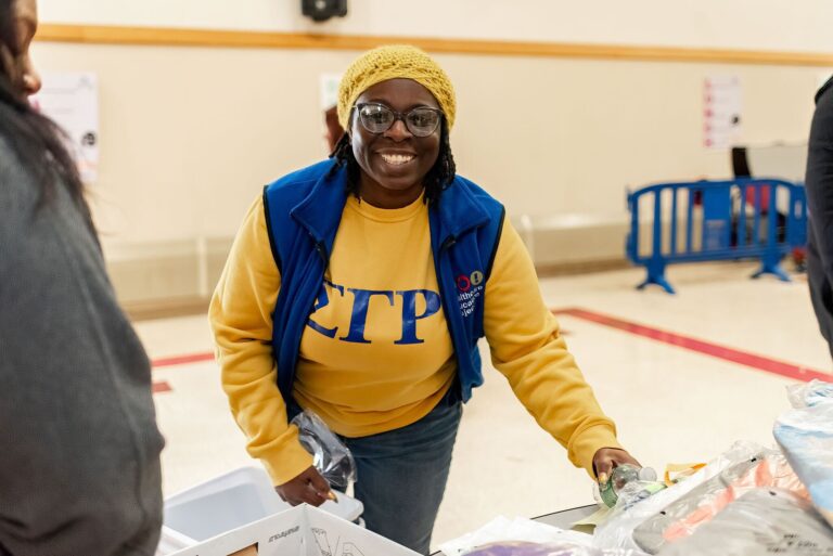 LaToya Jones-Joe helps distribute water to attendees at a 2024 Home for the Holiday event.