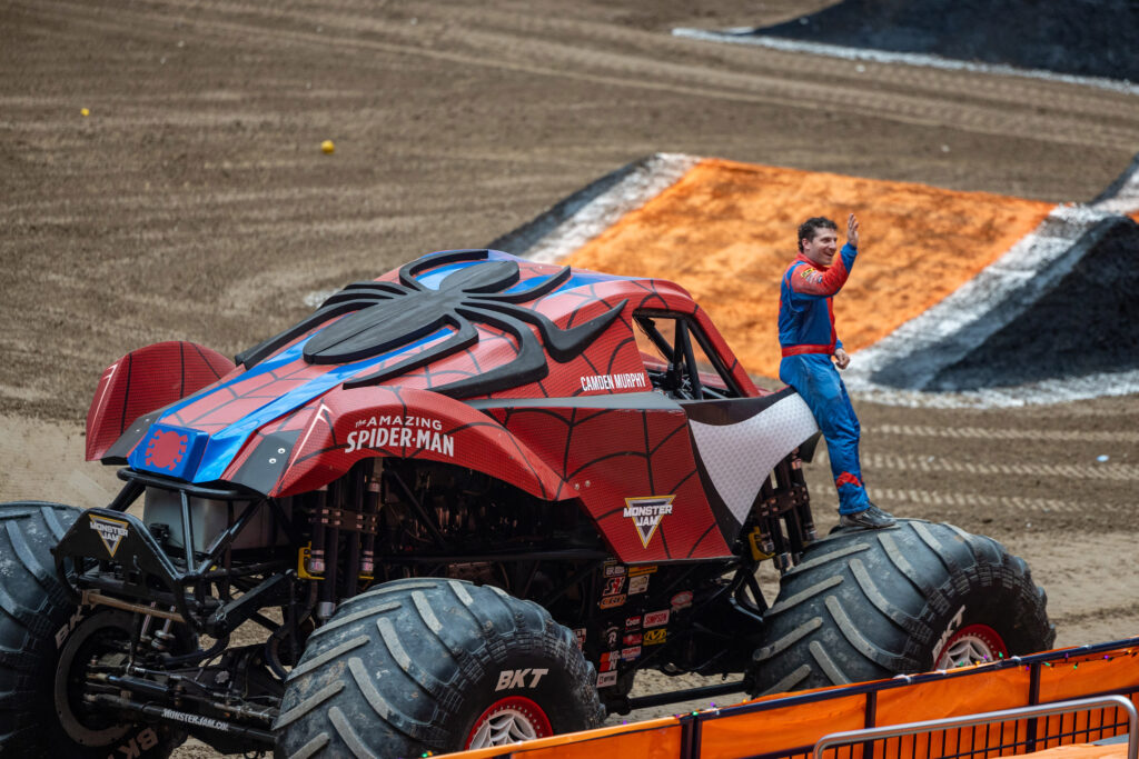 The Amazing Spider-Man waves to fans after driving the track at the driver rehearsal in the JMA Wireless dome Friday 10/23/26 ahead of Monster Jam