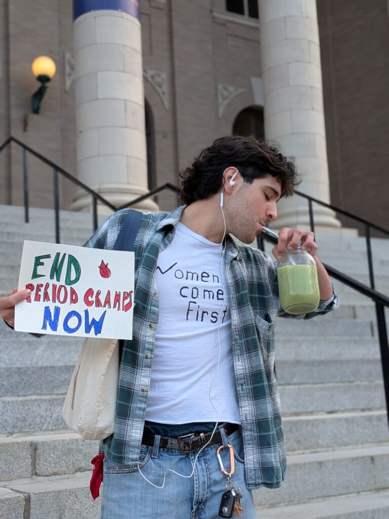 A man poses with a sign that says