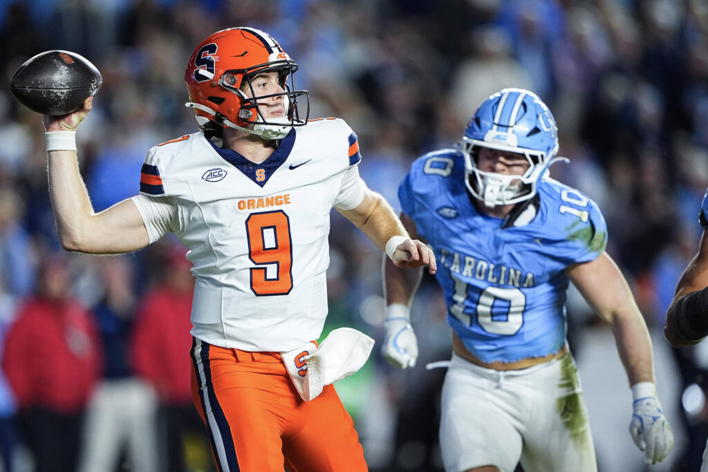 Quarterback Steve Angeli #9 of the Syracuse Orange evades pressure from linebacker Peyton Seelmann #10 of the North Carolina Tar Heels during the first half of their game at Kenan Stadium on October 24, 2026 in Chapel Hill, North Carolina.