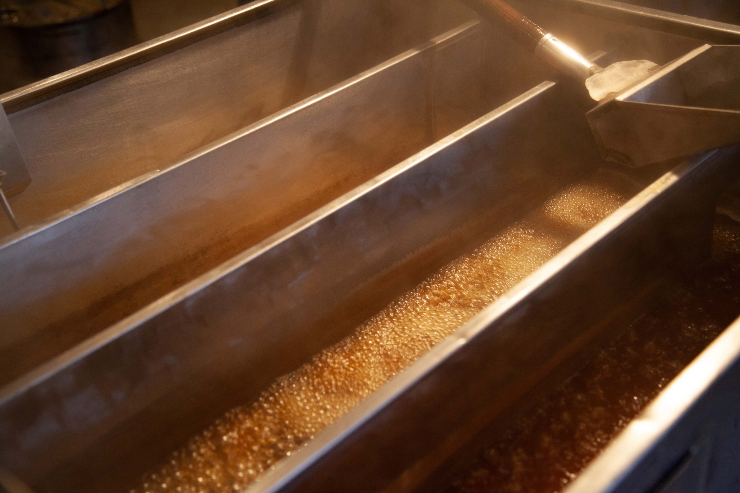 Maple syrup collects in vats at a farm.