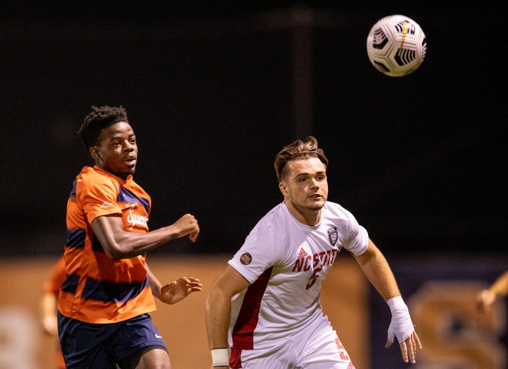 Syracuse's Julio Fulcar races NC State's Jamie Smith to the ball on Friday.