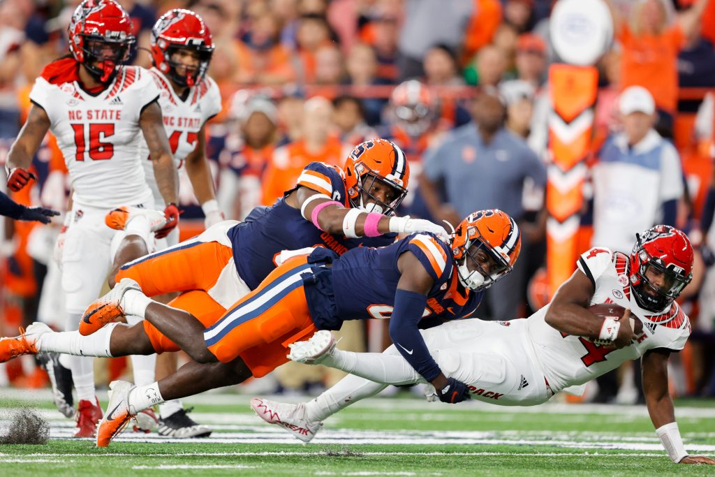 SYRACUSE, NY - OCTOBER 15: Mikel Jones #3 of the Syracuse Orange and Marlowe Wax #2 of the Syracuse Orange tackle Jack Chambers #14 of the North Carolina State Wolfpack at JMA Wireless Dome on October 15, 2022 in Syracuse, New York. (Photo by Isaiah Vazquez)