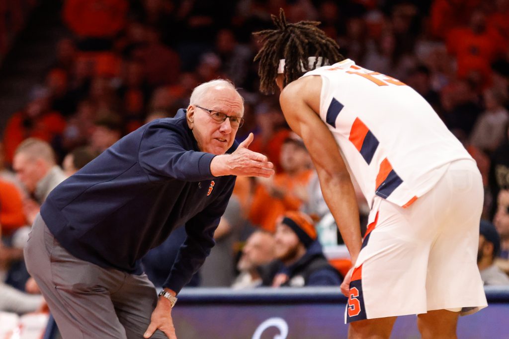 Syracuse Coach Jim Boeheim talks with Benny Williams while his team shoots free throws.