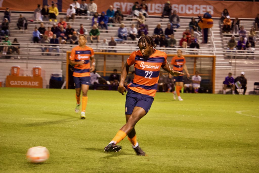 Syracuse's Olu Oyegunie (22) kicks the ball up midfield.