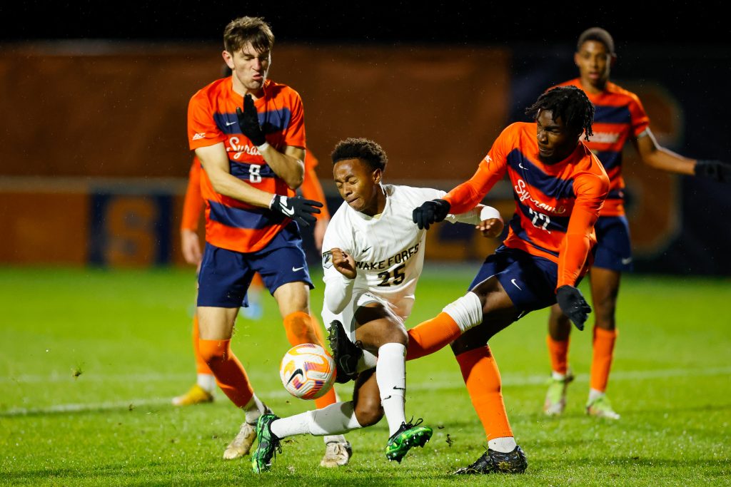 SU's Olu Oyegunle (22) and Wake's Chase Oliver (25) battle for the ball under the lights on Friday.