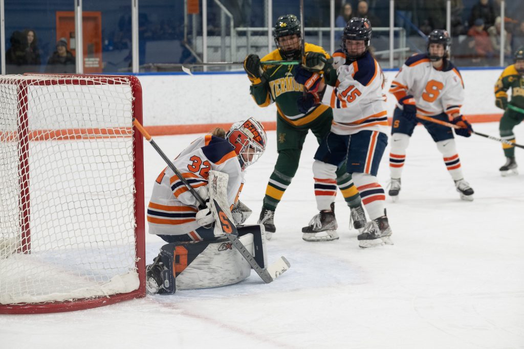 UVM and SU players watch in anticipation to see if SU goalie, Arielle DeSmet blocks the shot from UVM during the women's Ice Hockey game on Friday, December 9, 2022 at Tennity Ice Pavilion in Syracuse, NY.