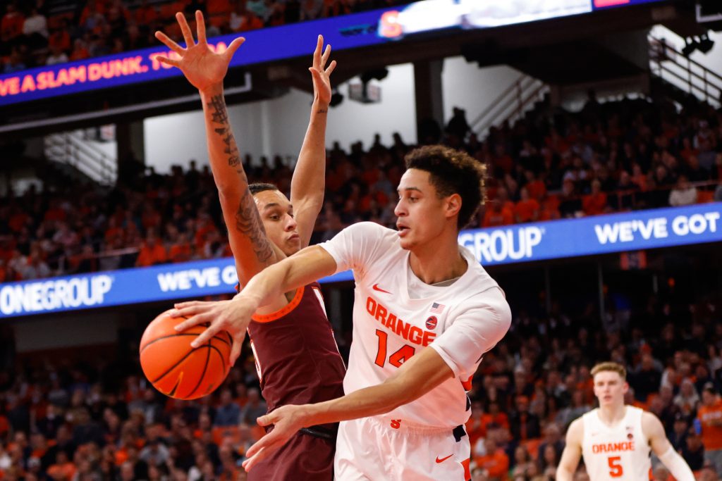 Syracuse's Jesse Edwards (14) passes the ball mid jump as Virginia Tech's Lynn Kidd (15) tries to block during an ACC basketball game Wednesday at JMA Wireless Dome.