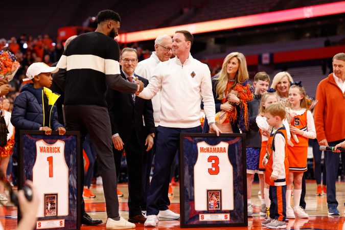Gerry McNamara (right) and Hakim Warrick shake hands during a jersey retirement ceremony on Saturday, March 4, 2023, at JMA Wireless Dome.