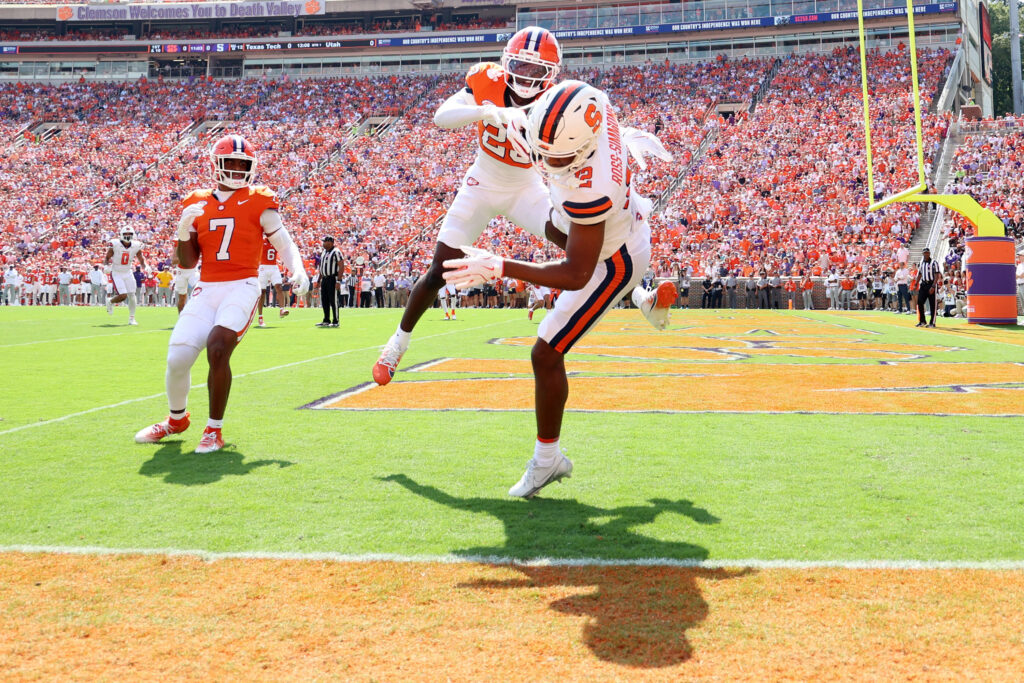 Justus Ross-Simmons #12 of the Syracuse Orange scores a touchdown during the first quarter as Ashton Hampton #23 of the Clemson Tigers defends at Memorial Stadium on September 20, 2025 in Clemson, South Carolina.