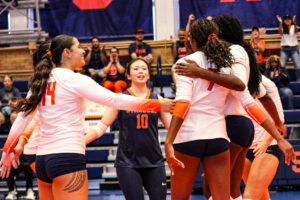 Members of SU's women's volleyball team huddle together during their match agains Le Moyne on Saturday.