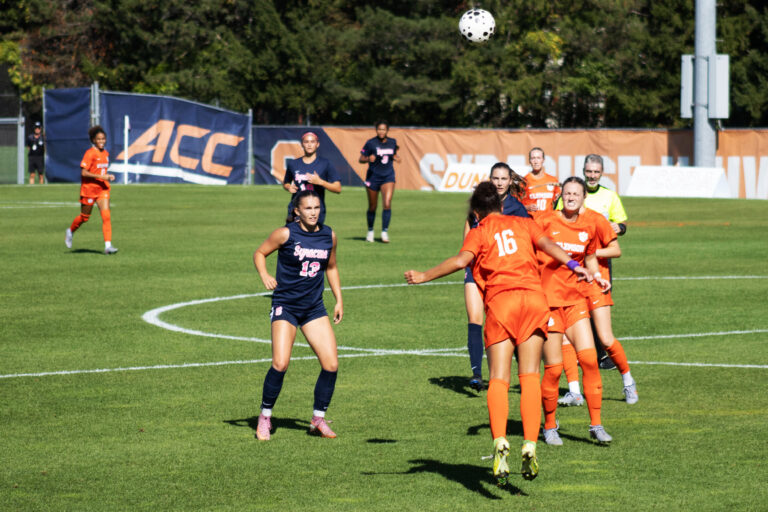 Syracuse players try to keep ball in play after Clemson player heads the ball: Syracuse player #13 Anna Rupert