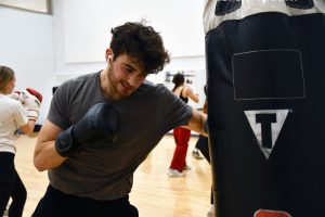 A boxer punches with his left hand on the heavy black bag in Flanagan Studio.