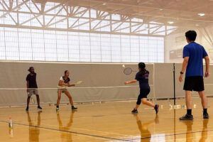 The Syracuse Club Badminton Team warms up before the start of their tournament on Saturday, October 4 at the Flanagan Gym.
