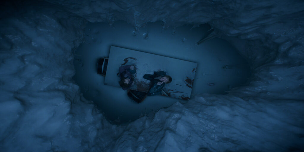In Stranger Things Season 5 Nancy Wheeler and Jonathon Byers sit on a wooden table in a room in Hawkins Lab that is rapidly filling with white melted metal.