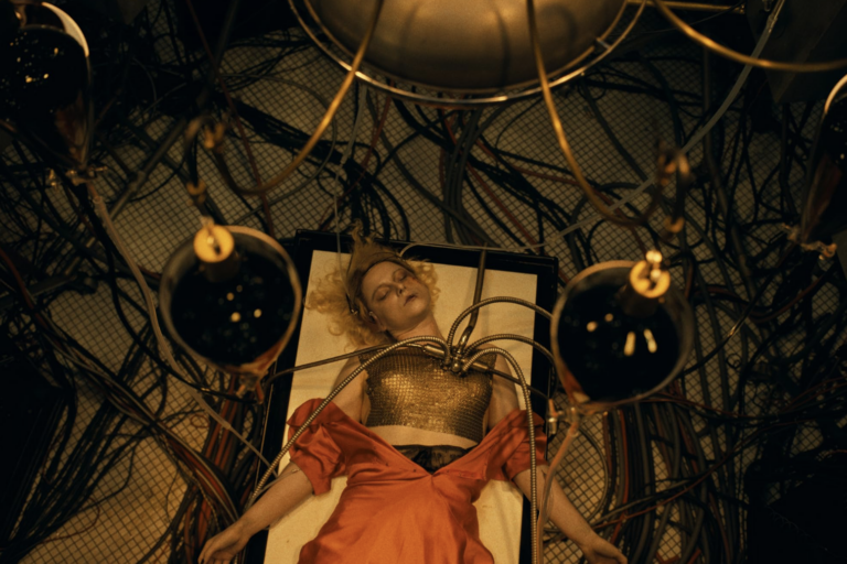 In "The Bride!" the titular character lays on a surgical bed with wires in her chest as she is being reanimated