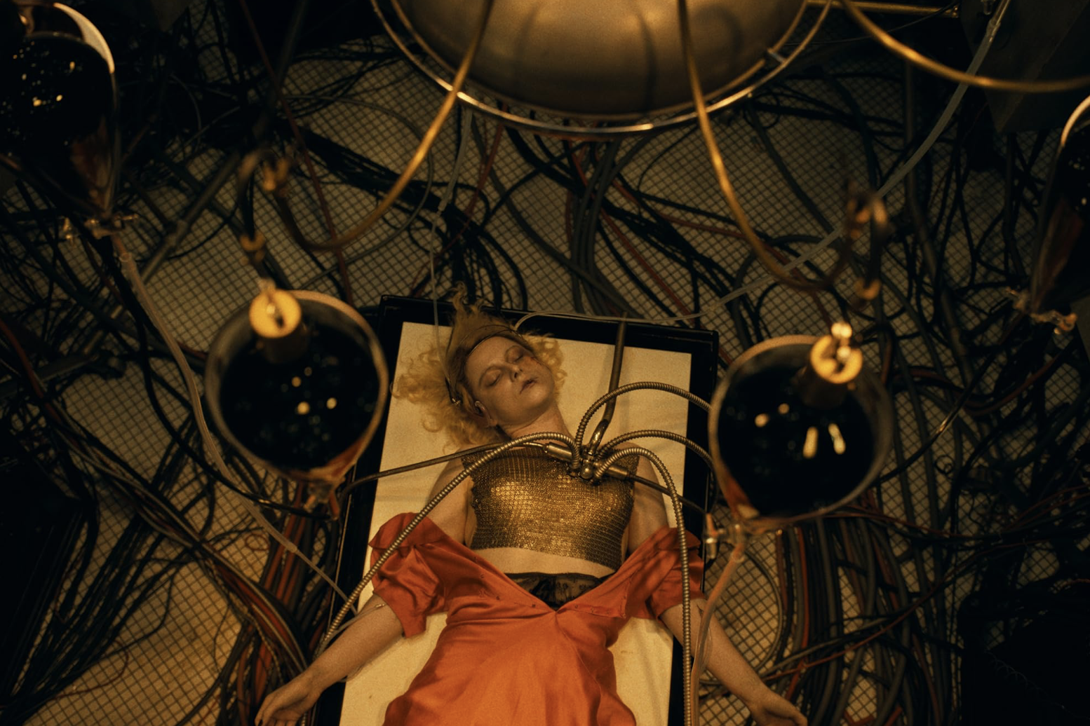 In "The Bride!" the titular character lays on a surgical bed with wires in her chest as she is being reanimated