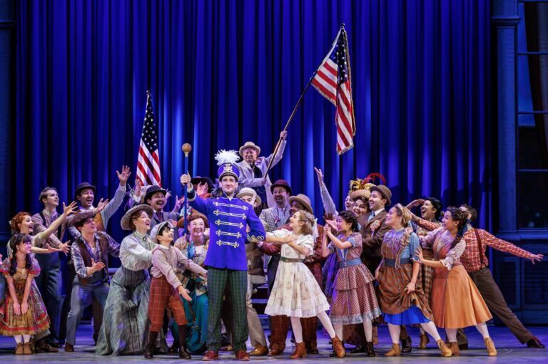 Cast of The Music Man national tour pose after big dance number.