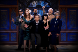 Cast of clue all together facing the camera with suits and dresses on