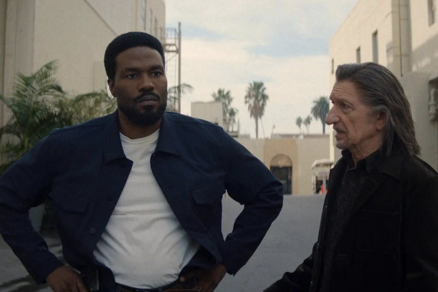 In 'Wonder Man' Yahya Abdul-Mateen II as Simon Williams and Ben Kingsley as Trevor Slatterly stand in a Hollywood back lot talking to one another.