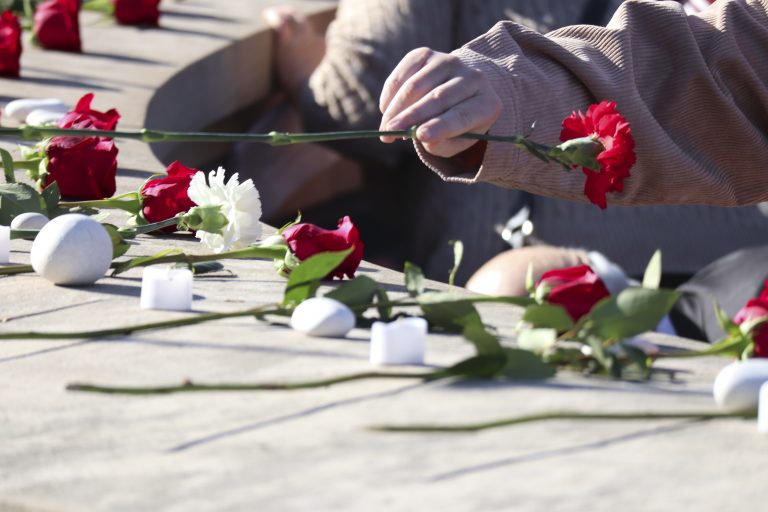 A parent lays a rose at the Syracuse University Remembrance Scholar Rose-Laying Ceremony, closing out a week of events to remember the lives lost in the Pan Am Flight 103 bombing