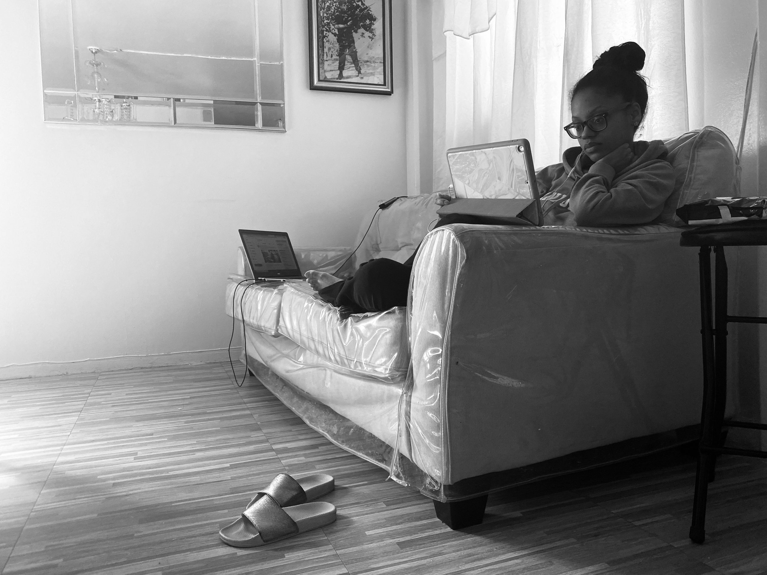 Student sitting on couch working on laptop