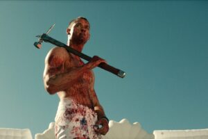 bloody man with hammer in front of blue sky