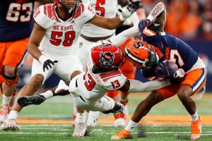 SYRACUSE, NY - OCTOBER 15: Devaughn Cooper #7 of the Syracuse Orange attempts to escape Tyler Baker-Williams #13 of the North Carolina State Wolfpack at JMA Wireless Dome on October 15, 2022 in Syracuse, New York. (Photo by Isaiah Vazquez)