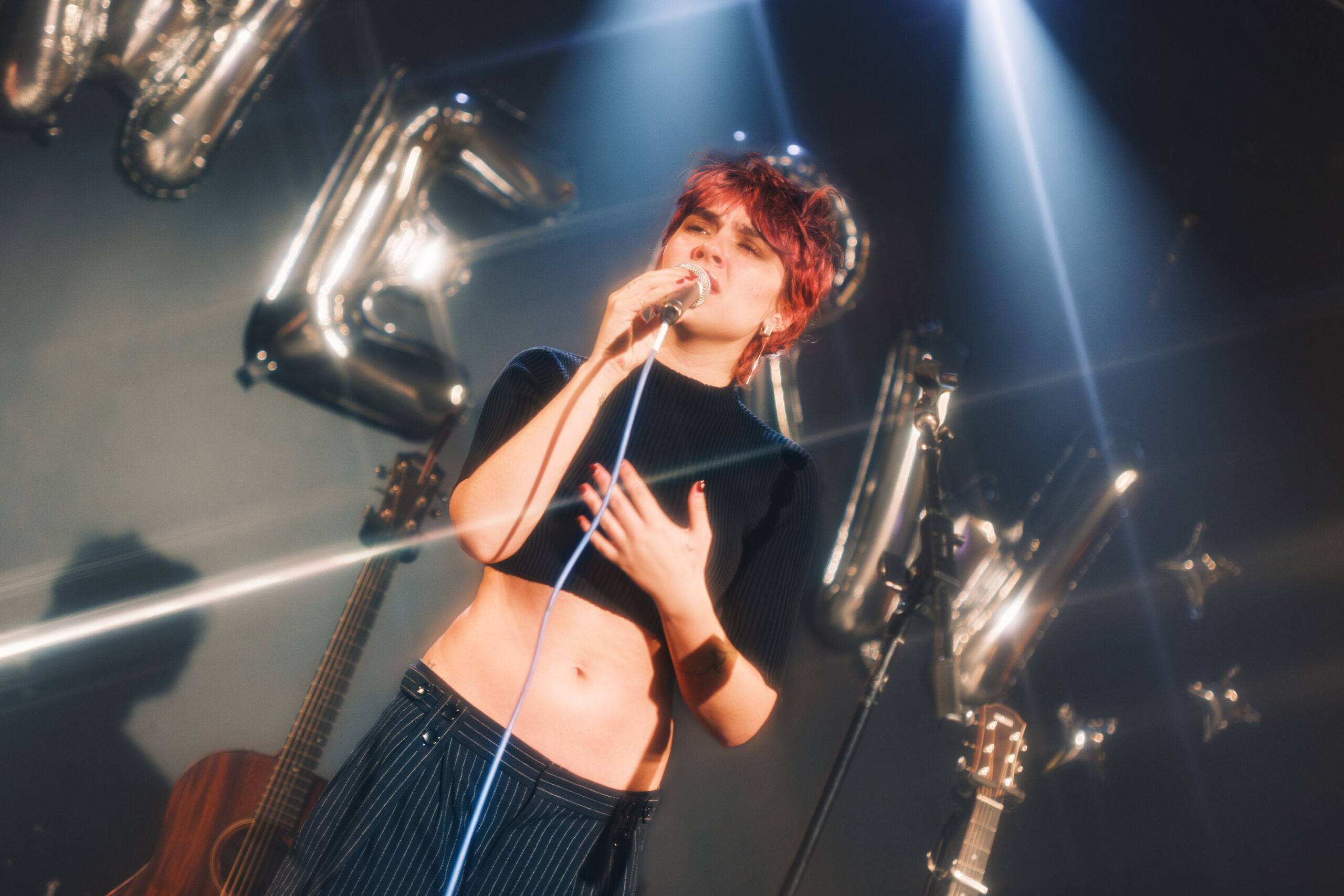 Person with red hair singing on stage