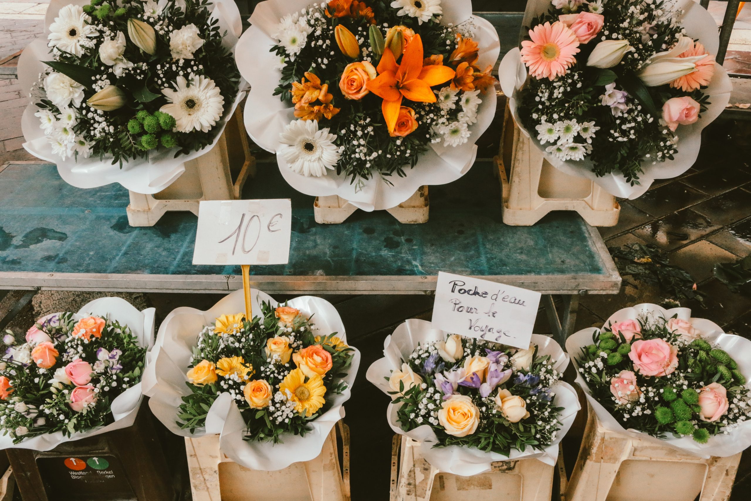 Bouquets of flowers sit side by side at a florist.