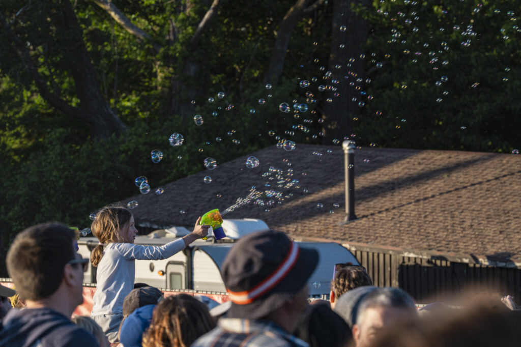 A young concertgoer plays with a bubble gun on the lawn during CAKE's sold-out performance at Beak & Skiff Apple Orchards in LaFayette on May 30, 2026.