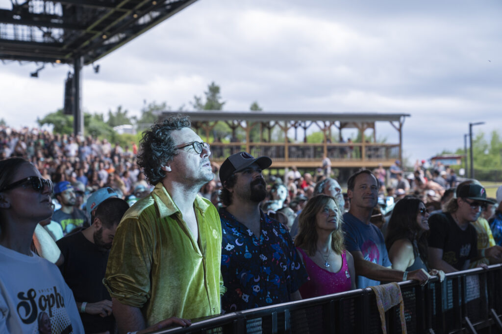 A fan watches Phish from the barricade at Empower Federal Credit Union Amphitheater at Lakeview in Syracuse, N.Y., on Tuesday, July 21, 2026. Many members of the band’s devoted following, commonly called “Phans,” had attended dozens or even more than 100 Phish concerts, traveling from across the country to reconnect with friends and the larger fan community.