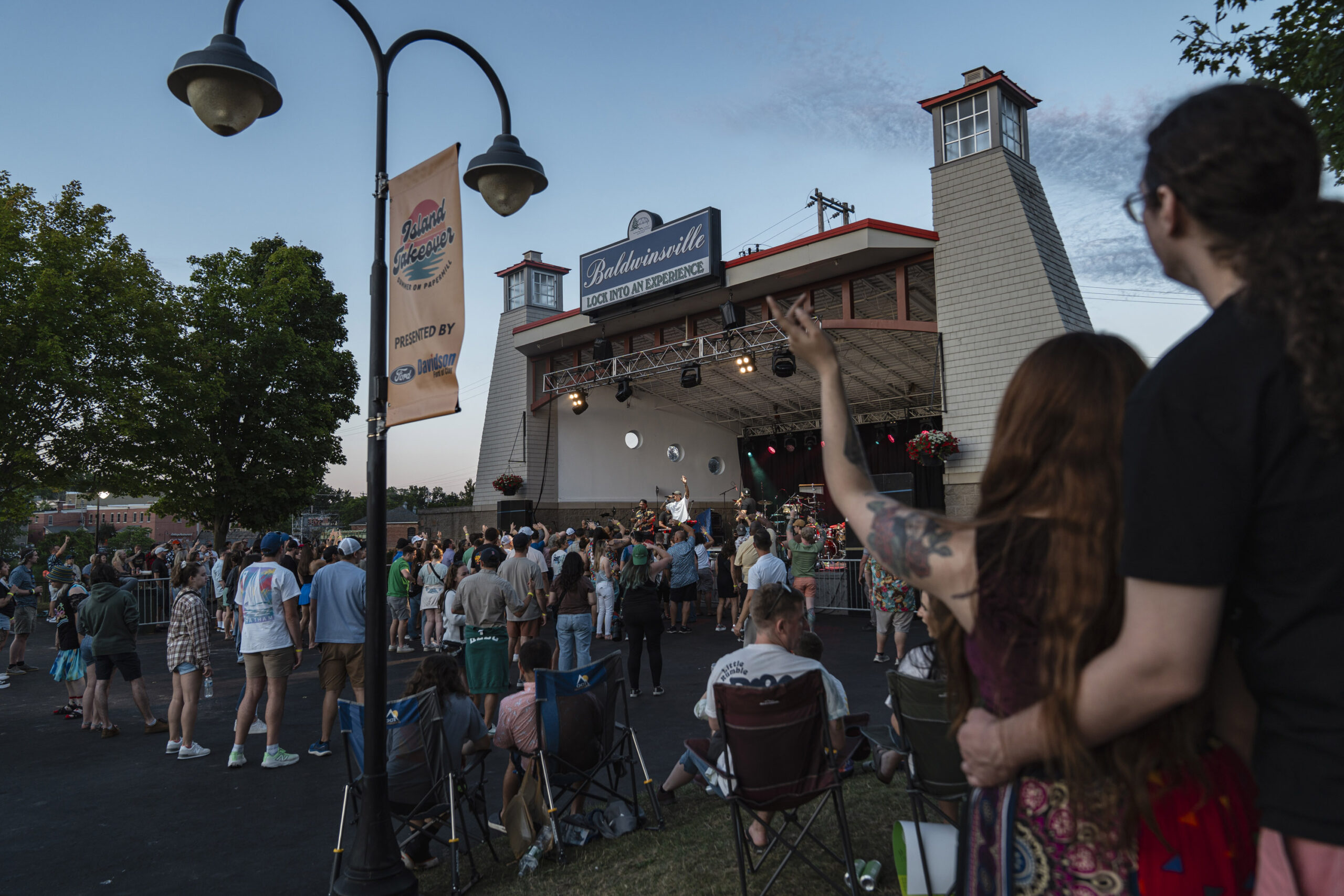 Fans wave their hands along with Seven Suns during the Honolulu-based group’s performance at Paper Mill Island in Baldwinsville on Friday, Aug. 14, 2026. Photo by Matt Hofmann.