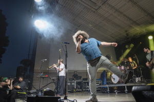 Ripe frontman Robbie Wulfsohn kicks a leg into the air while racing across the Paper Mill Island stage Friday night. His animated performance matched the band’s funk-heavy sound, keeping the crowd moving throughout the headlining set. Photo by Matt Hofmann.