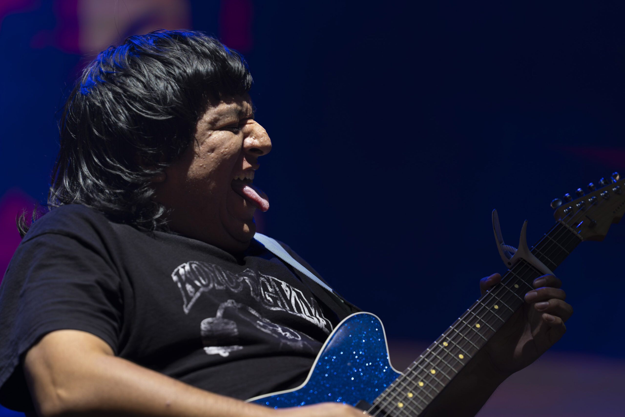 Ben Quad guitarist Edgar Viveros performs under blue stage lights at Empower Federal Credit Union Amphitheater at Lakeview in Syracuse, N.Y., on Thursday, Sept. 24, 2026. Photo by Matt Hofmann.