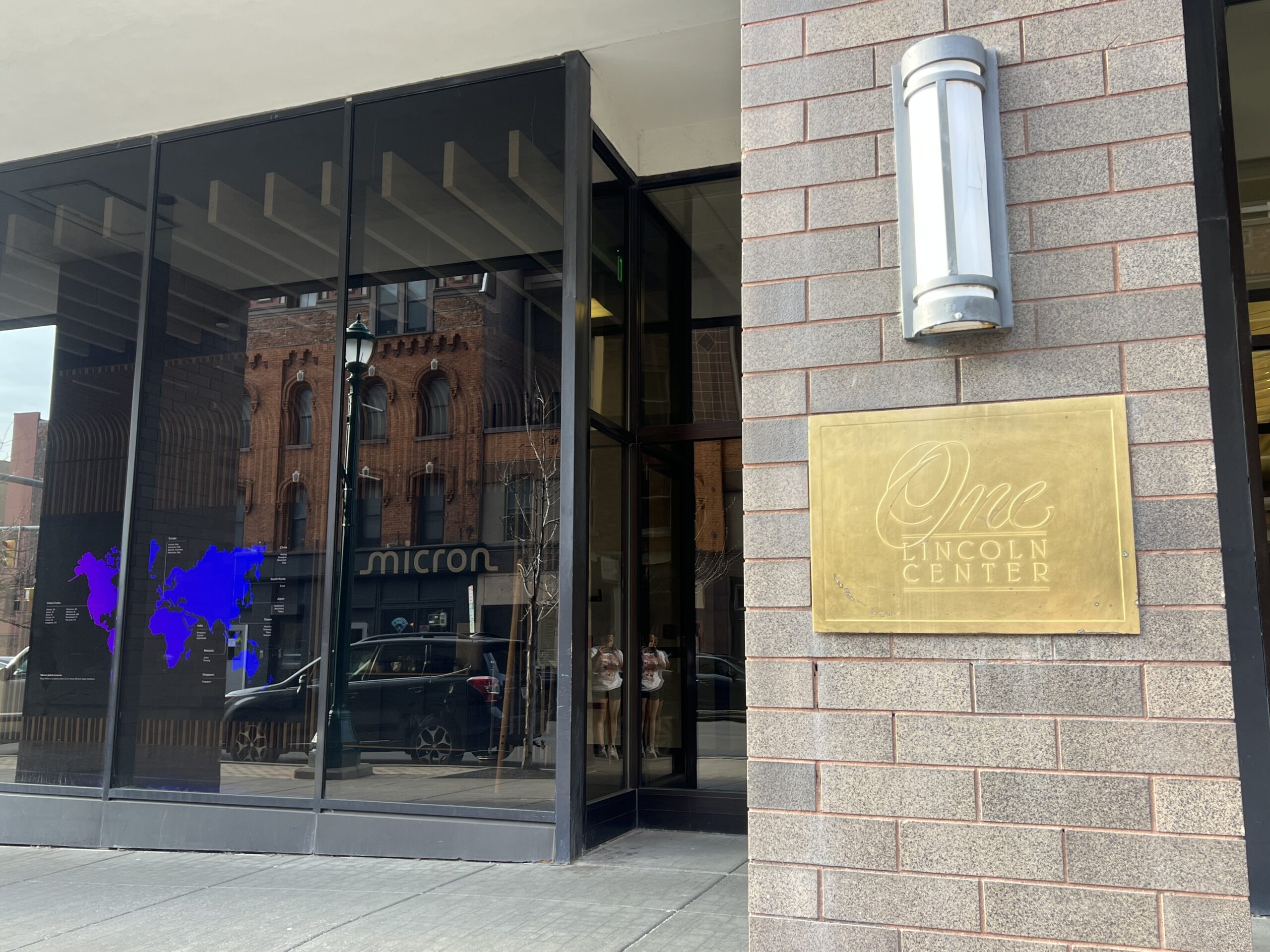 An office entrance with a plaque, light, and open windows.