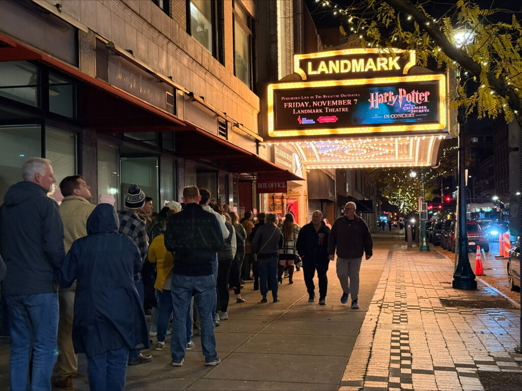 People standing outside Landmark Theater at night