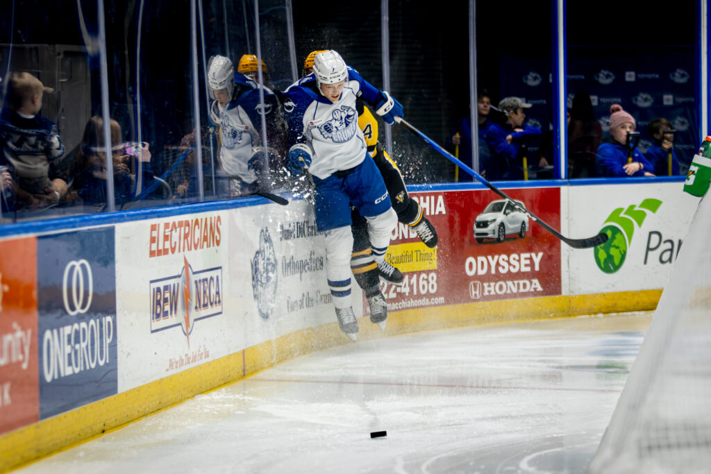 Syracuse Crunch defenseman Simon Lundmark crushes a player on the Wilkes Barre/Scranton Penguins against the boards during a 6-0 win on Saturday, January 3rd, 2025, at the Upstate Medical University Arena.