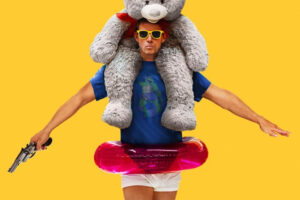 Channing tatum with stuffed animal on his back, floaty around his waist and a gun in his hand