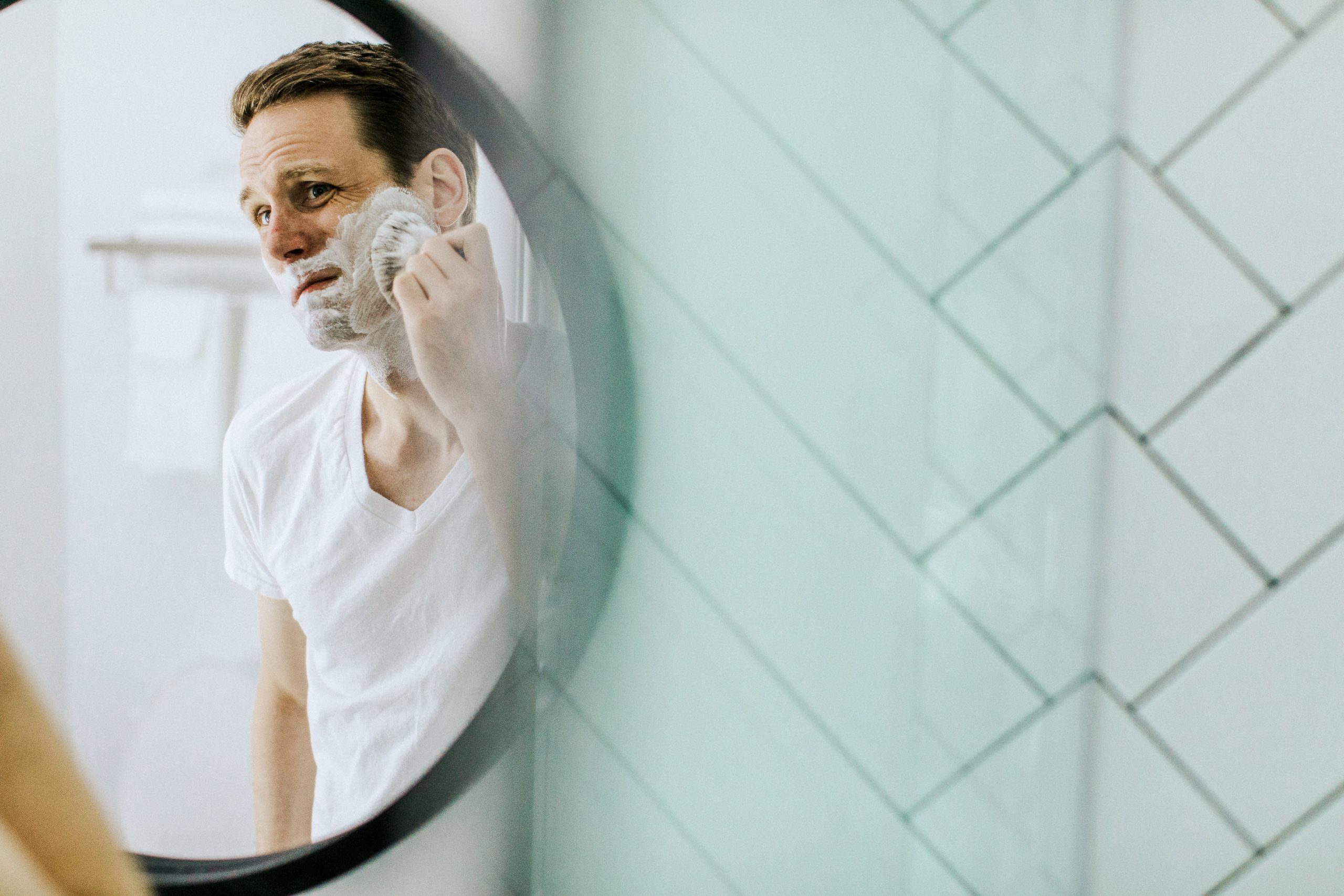 A person washes his face with a face brush.